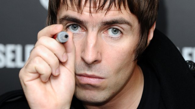 Liam Gallagher holding a pen 